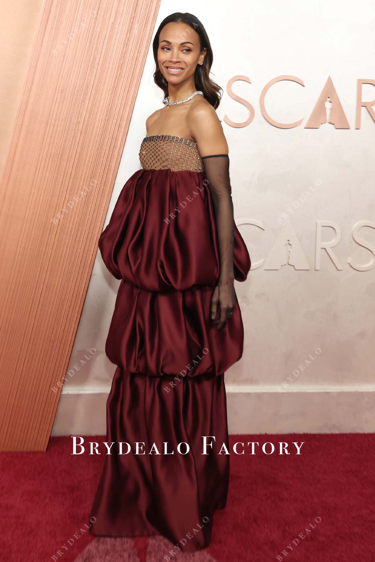 Zoe Saldaña burgundy straight across 2025 Oscars red carpet dress